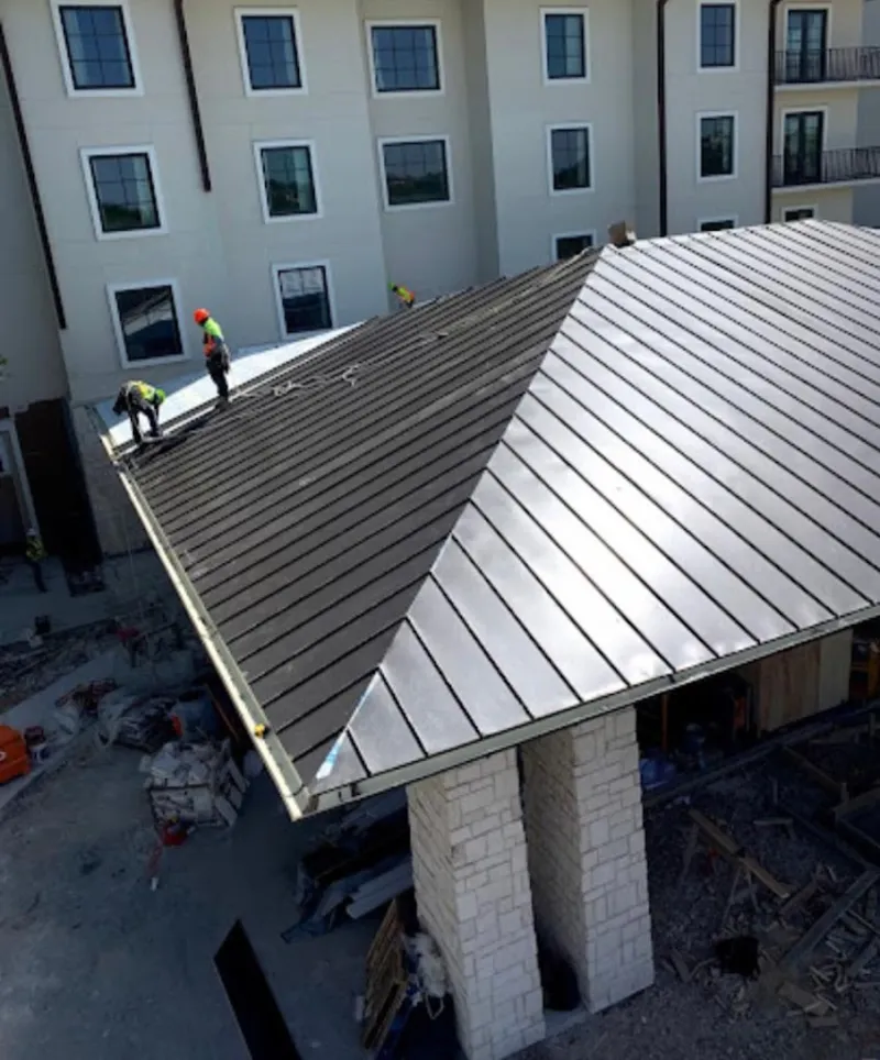 Crew installing standing seam metal roof panels on a commercial project in Lake Arrowhead